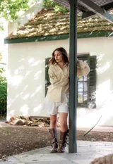 Camisa de manga larga con diseño abullonado, confeccionada en tela bordada con motivos florales. Presenta cierre frontal con botones y puños elásticos.