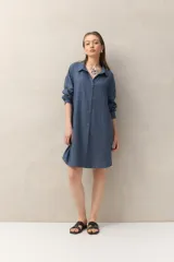 Vestido camisero azul de lino, corte recto, con cuello camisero, mangas largas y cierre frontal con botones tipo mostacilla.