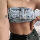 Top strapless de denim celeste con apliques metálicos y hebilla central.