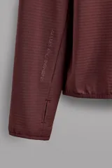 Sudadera técnica color bordó con capucha, cierre frontal completo y bolsillo en el pecho con cremallera oculta. Tejido elástico con interior efecto polar y estructura waffle. Presenta puños adaptables con ajuste para el pulgar.
