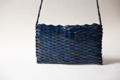 Cartera bandolera rectangular de diseño estructural, hecha a mano, con textura superpuesta de piezas en tono azul profundo y correa larga de cuentas.