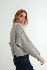 Cardigan de punto color marrón chocolate, con cuello redondo, cierre frontal de botones y diseño de costuras verticales visibles. Presenta puños y ruedo acanalados.