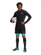 Short deportivo Under Armour de la colaboración con Mansory, en color negro. Presenta un diseño de doble capa con calza interna integrada en color turquesa, cintura elástica con cordón y logos de la marca y la colaboración en contraste.