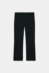 Pantalón cropped negro de tiro alto, con cintura con trabillas y falsos bolsillos delanteros. Cierre frontal con cremallera, botón y ganchos metálicos.
