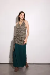 Vestido largo de gasa color petróleo con estampado floral en tonos beige y azul. Tiene escote en V pronunciado, espalda baja, drapeados en la cadera y lazo para atar de múltiples formas.