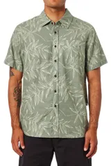 Camisa manga corta verde militar con estampado botánico de hojas, cuello camisero, cierre frontal de botones y un bolsillo ojal en el pecho.