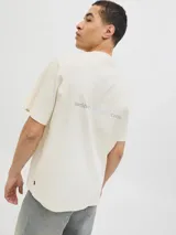 Remera de manga corta color beige, confeccionada en algodón, con cuello redondo y diseño clásico de corte recto.
