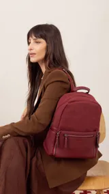 Mochila negra combinada con nobuck, bolsillo amplio adelante con broche y cierre, bolsillos en los costados, asas regulables y bolsillos internos.