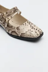 Zapato tipo Mary Jane de charol sintético color rojo, con punta cuadrada y triple tira con hebillas.