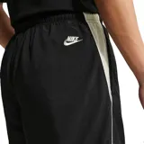 Pantalón deportivo Nike de corte holgado, color negro, con cintura elástica y puños ajustados en los tobillos. Presenta el logo de la marca bordado en color blanco en la parte superior del muslo izquierdo.
