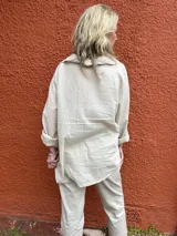 Camisa Milena de color beige, de manga larga con puños arremangados y cuello abierto con escote en V.