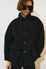 Chaqueta ZW Collection de color negro, con cuello solapa, manga larga y bolsillos delanteros de plastrón con solapa. Presenta cierre frontal con botones y bajo recto.