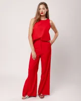 Pantalón negro de lino, tiro alto, corte palazo, con elástico en la pretina trasera, cierre delantero y broche interno. Tiene bolsillos laterales, dobladillo invisible y tajos a los costados.