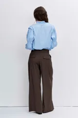 Blusa celeste de manga larga con puños fruncidos y elásticos, escote en V con cuello alto con volados y delicados bordados florales en el pecho.