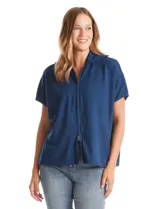 Cardigan de punto azul, con cierre frontal metálico completo, cuello con solapa y mangas cortas de sisa caída. Presenta un corte recto y holgado.