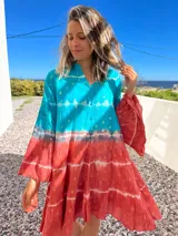 Vestido camisero corto con estampado batik en tonos turquesa y terracota con detalles dorados, cuello mao y mangas 3/4 acampanadas.