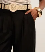 Pantalón wide leg de cintura alta color crudo, confeccionado en viscolino, con trabillas en la cintura, cierre tradicional y pliegues. Incluye cinturón de rafia artificial.