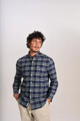 Camisa de manga larga confeccionada en tejido de franela con estampado de cuadros en tonos azul marino y verde. Presenta cuello abotonado, cierre frontal con botones y un bolsillo en el pecho con el logo bordado de la marca.