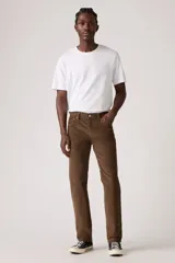 Pantalón de pana color marrón, corte slim fit, con cinco bolsillos y cierre de botón y cremallera.