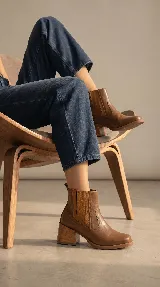 Bota tipo chelsea de cuero negro con paneles elásticos laterales y taco cuadrado de madera de 6 cm.