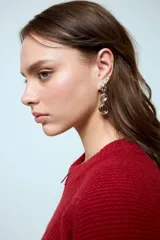 Caravanas colgantes de diseño moderno, compuestas por tres piezas circulares en degradado: una esfera metálica plateada superior, una piedra central en tono ámbar y una piedra inferior en tono ahumado, todas engarzadas en metal plateado.