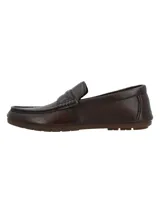 Mocasines de cuero marrón oscuro, con diseño clásico de tipo penny loafer, costuras visibles en el empeine y suela plana de goma.