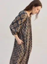Vestido midi de diseño suelto con estampado geométrico en tonos marrones y beige, mangas 3/4 y cuello mao.