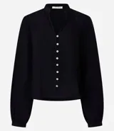 Camisa negra de viscosa sostenible, con escote en V, mangas largas abullonadas con puños elásticos y cierre frontal con botones. Presenta detalles de canalé en los hombros y la espalda.