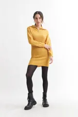 Vestido corto de tejido acrílico color mostaza, con cuello polo y medio cierre frontal.