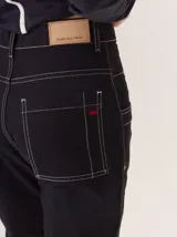 Jean de corte recto confeccionado en gabardina de algodón, color negro con costuras en contraste color blanco. Presenta bolsillos delanteros y traseros con pespuntes visibles.