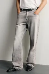 Jeans flare fit de denim negro, tiro medio, ajustados arriba y con botamanga acampanada. Cuentan con cinco bolsillos, lavado efecto gastado y bajo con acabado irregular. Cierre frontal con cremallera y botón.