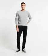 Pantalón de jean negro para hombre, modelo básico de corte ajustado, con bolsillos laterales y traseros, trabillas en la cintura y cierre frontal de botón y cremallera.