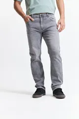 Pantalón de jean corte regular con tiro medio, diseño clásico de cinco bolsillos, cierre frontal con botón y bragueta, y pasacintos en la cintura.