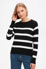 Sweater de punto con diseño de rayas horizontales en azul marino sobre fondo blanco, de corte holgado, cuello redondo y mangas largas con puños acanalados.