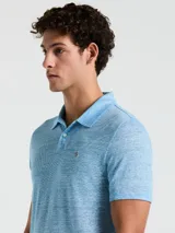 Polo celeste con textura jaspeada, cuello clásico, manga corta y logo bordado en el pecho.
