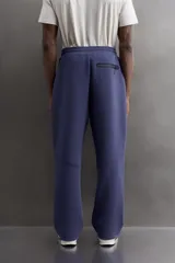 Pantalón jogger relaxed fit Zara Athleticz de tejido técnico compacto elástico con mezcla de algodón. Presenta cintura elástica ajustable con cordón, bolsillos laterales en la cadera, bolsillo trasero con cierre de cremallera, bajo ajustable con elástico y detalle de logo estampado en la pernera.