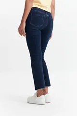 Jean straight de tiro medio, color azul denim, con corte recto y ruedo desflecado.