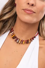 Collar corto con bastones de piedra natural en tonos tierra y mostacillas rojas.