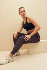 Pantalón tipo babucha de tiro alto, con cintura elástica ancha, bolsillos laterales y puños ajustados en los tobillos.