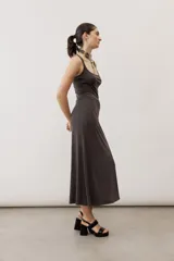 Vestido largo color verde suave, sin mangas, con escote redondo y silueta al cuerpo que se ensancha levemente hacia el dobladillo.