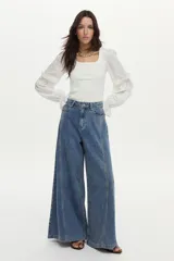 Pantalón jean de pierna ancha con calce relajado y detalles de costuras decorativas verticales en el frente, color azul.
