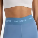 Calza deportiva New Balance de tiro alto, color azul claro, ajustada al cuerpo y con banda elástica en la cintura con logo repetido.