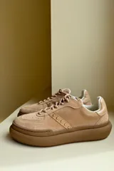 Championes blancos de cuero con cordones y apliques metálicos.