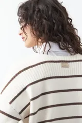 Sweater de tejido de punto con diseño de rayas horizontales en tonos bordó y rojo. Presenta cuello redondo, mangas largas con hombros caídos y terminaciones acanaladas en puños, cuello y ruedo.