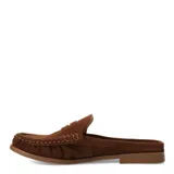 Zuecos de gamuza marrón estilo mocasín, abiertos en el talón con diseño slip-on. Presentan costuras pespunteadas visibles, detalle de tira sobre el empeine con un aplique metálico dorado y suela plana.