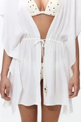 Vestido corto estilo túnica color blanco, de diseño oversized y mangas cortas, con escote en V pronunciado y cordón ajustable en la cintura.