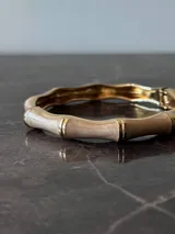 Pulsera rígida esmaltada color dorado, beige y blanco.