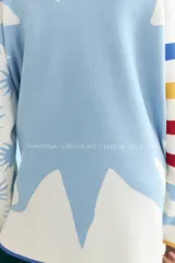 Cardigan de punto con cuello redondo, botones frontales y diseño de rayas horizontales en tonos blanco, celeste, azul, amarillo y rojo. Presenta puños y ruedo en azul.