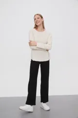 Sweater de punto color crudo, con cuello redondo y mangas largas.