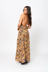 Vestido largo color ocre con estampado floral, escote en V y espalda descubierta.